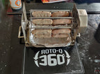 ROTO-Q 360 rotisserie setup holding sausages, resting on a ROTO-Q 360 Premium Cooking Mat.
