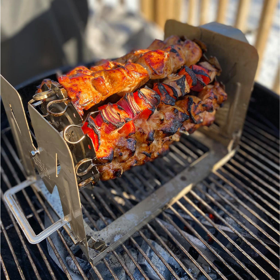 ROTO-Q 360 Skewer Set with grilled meat and vegetable kabobs cooking over a charcoal grill.