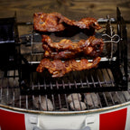 Meat grilling on a ROTO-Q 360 skewers over charcoal