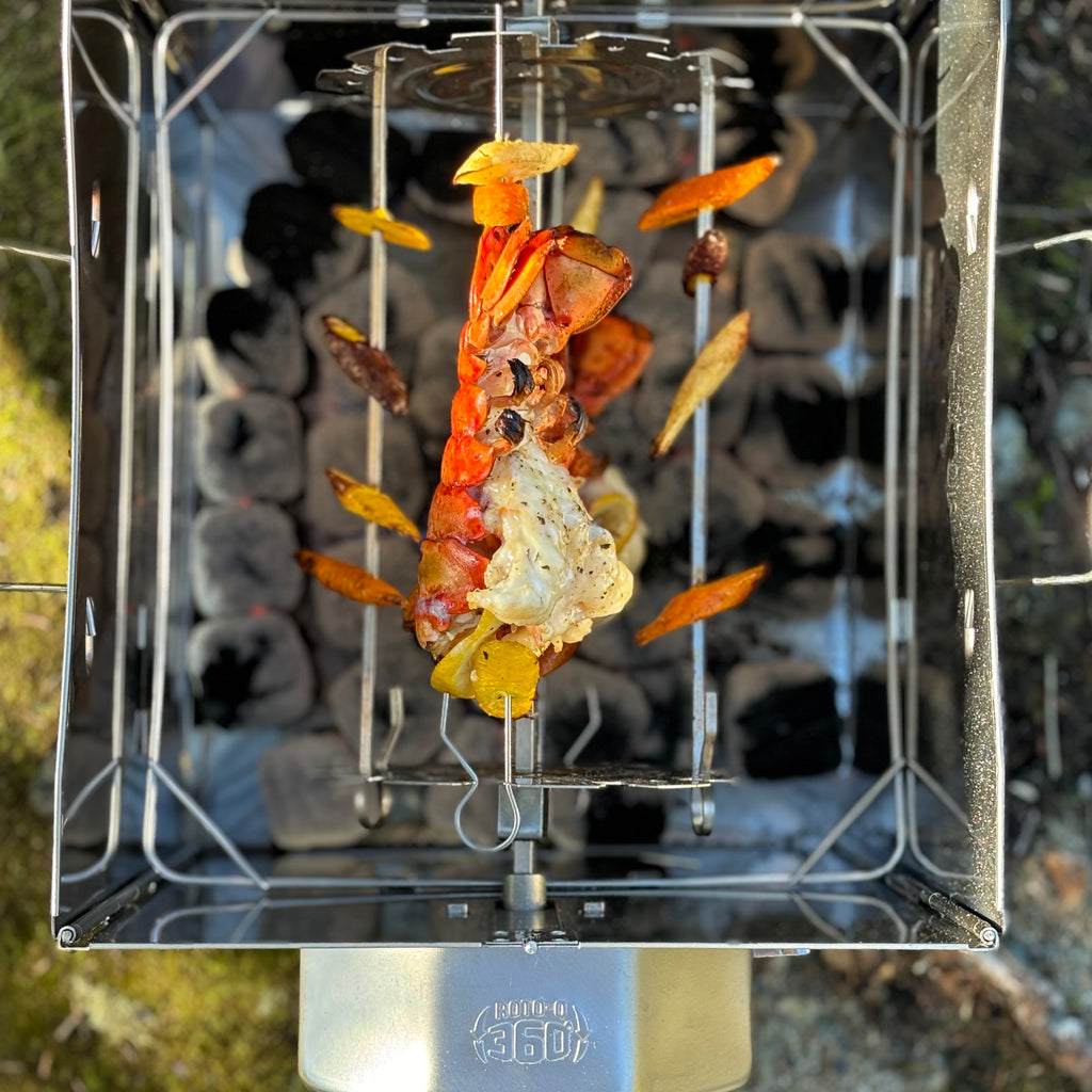 Lobster and vegetable skewers roasting inside a ROTO-Q 360 foldable grill.