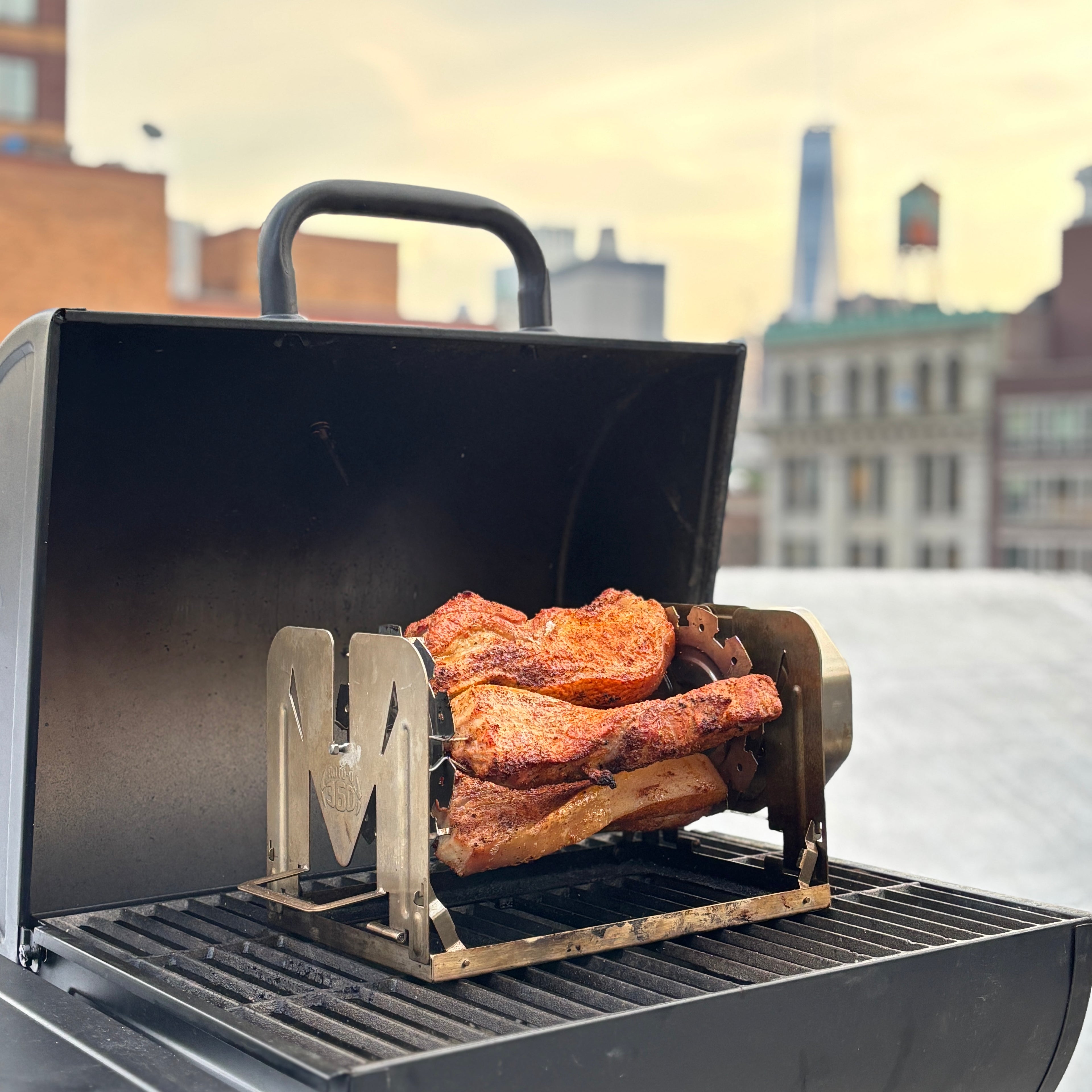 Meat cooking on a ROTO-Q 360 skewer set on an outdoor grill