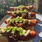 Plated chili hot dogs topped with sauce and fresh herbs