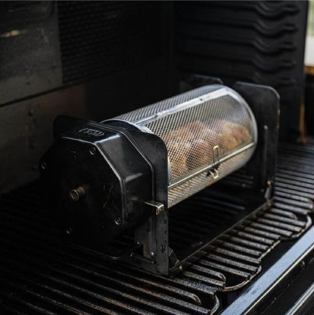 Black ROTO-Q 360 rotisserie unit with a round rotisserie basket sitting on a grill grate