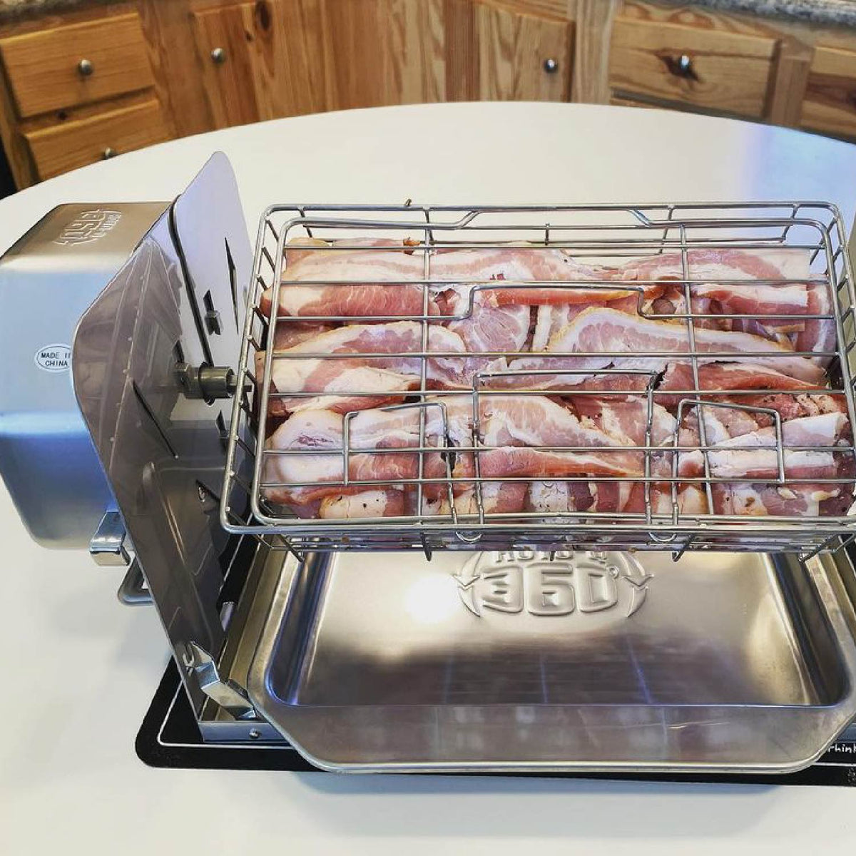 Raw bacon strips arranged inside a ROTO-Q 360 Rotisserie Cage (Flat) attachment.